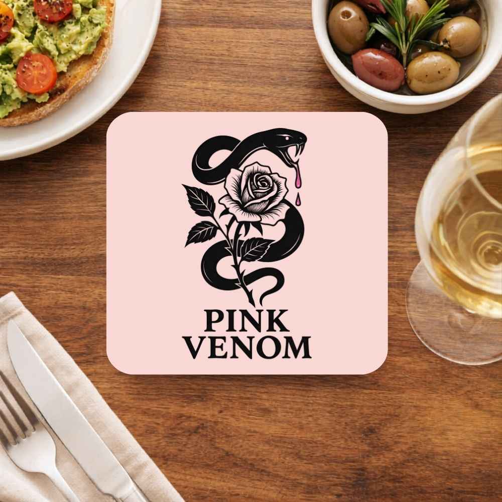 Coaster with 'Pink Venom' design on a wooden table with food and drink. Black Pink Coaster.