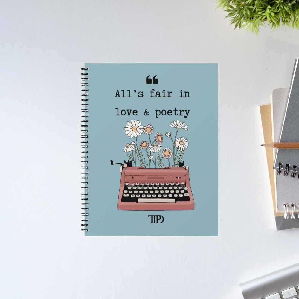Taylor Swift Love & Poetry spiral notebook with the line 'All's fair in love & poetry' above a pink typewriter sprouting daisies, on a dusty blue cover – The Banyan Tee