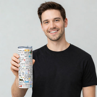 Man holding a colorful Taylor Swift tumbler with text and graphics on a plain background
