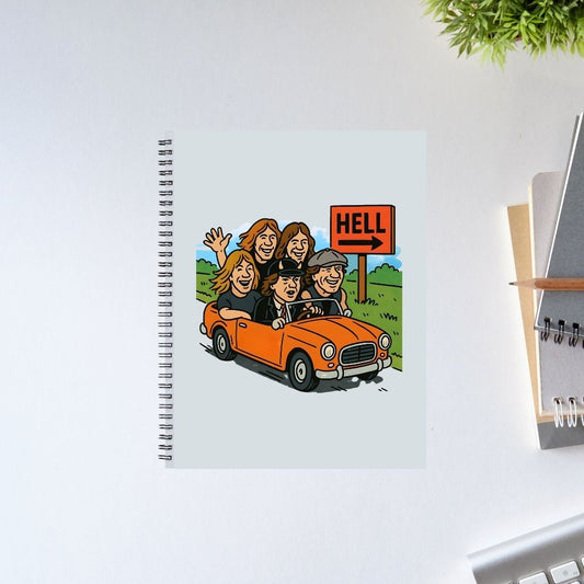 Notebook with a cartoon illustration of people in a car and a 'Hell' sign on a white surface. AC/DC Notebook The Banyan Tee