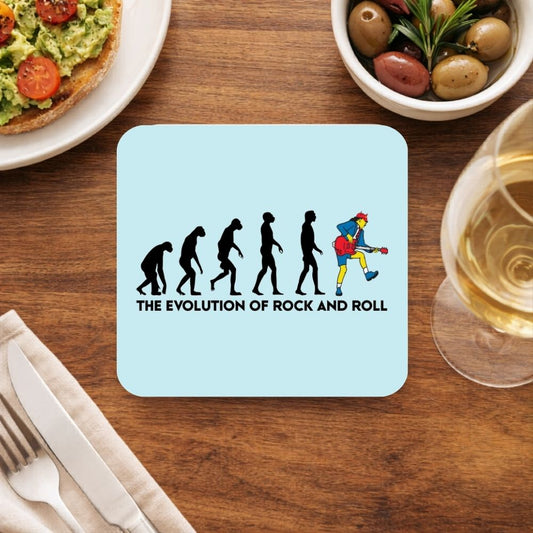 Coaster with 'The Evolution of Rock and Roll' design on a wooden table with food and drink. AC/DC Coaster The Banyan Tee