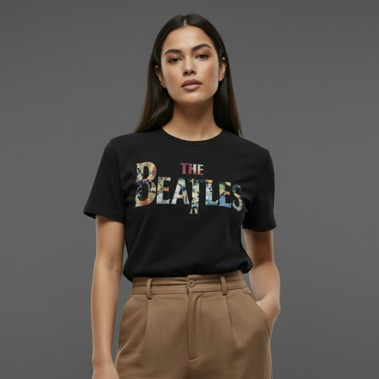 Person wearing a black 'The Beatles' t-shirt against a gray background