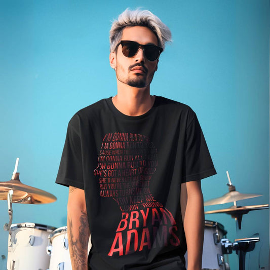 Man wearing a black t-shirt with red text standing in front of a drum set against a blue sky. Bryan Adams Run To You T-shirt