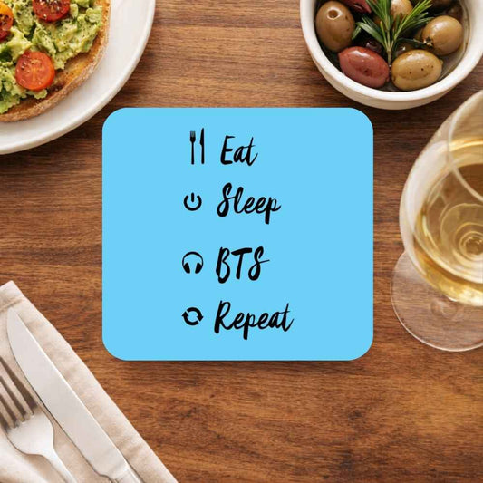 BTS Eat Sleep Repeat coaster with blue fandom humor design on wooden table setting – durable cork-backed drink coaster set, unique K-pop home decor gift for BTS ARMY fans