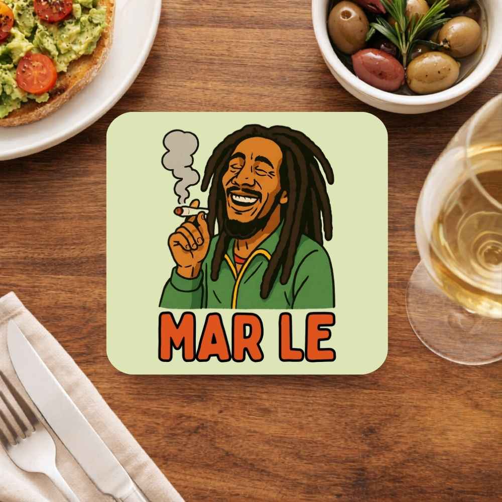 Coaster with a cartoon character and 'MAR LE' text on a wooden table with food and drink. Bob Marley Gift Merch The Banyan Tee