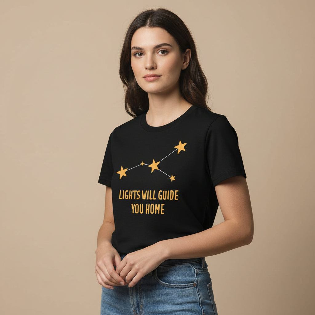 Black t-shirt with yellow star design and text 'LIGHTS WILL GUIDE YOU HOME' on a white background coldplay the bnayan tee 