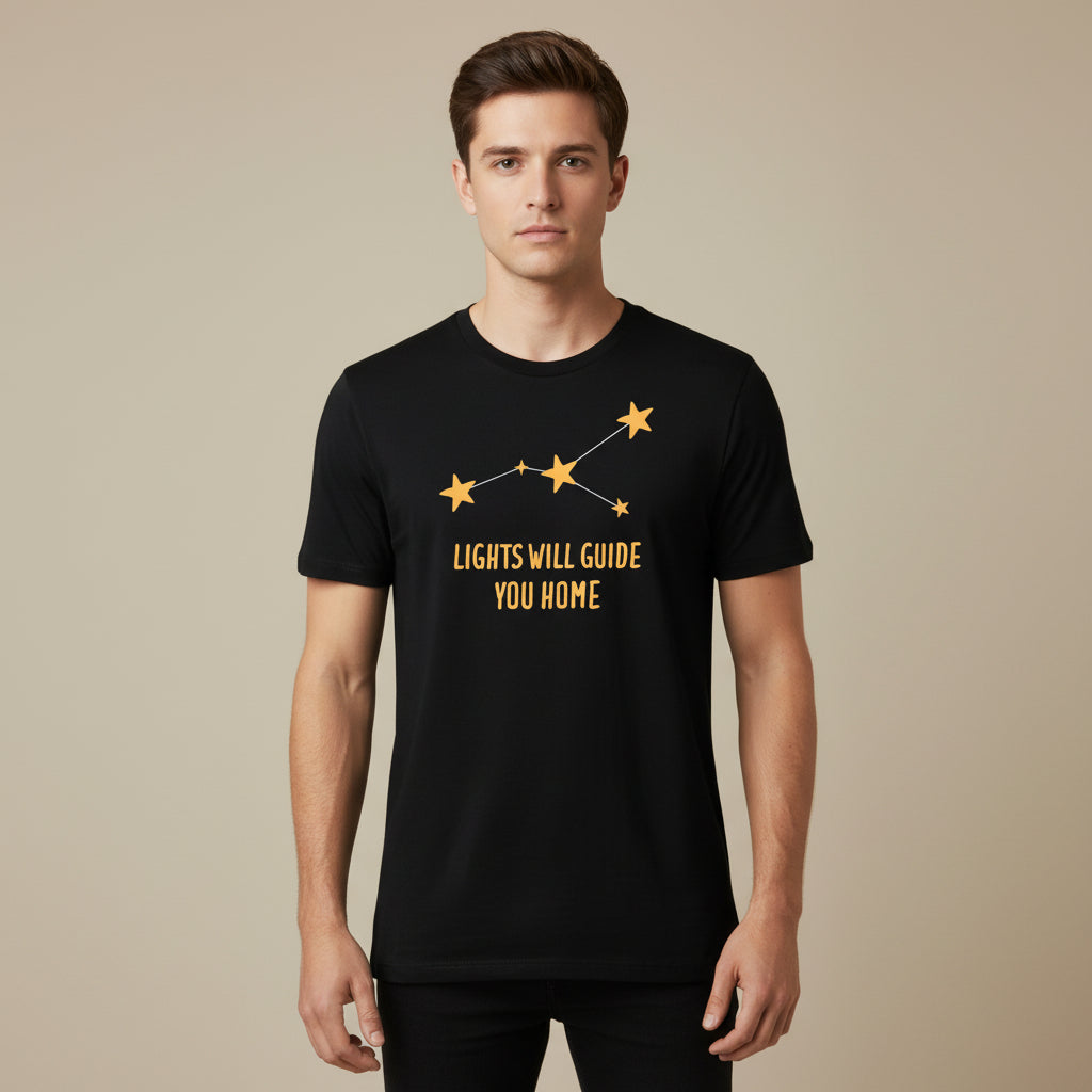 Black t-shirt with yellow star design and text 'LIGHTS WILL GUIDE YOU HOME' on a white background coldplay the bnayan tee 