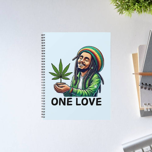 Notebook with a design of a person holding a cannabis leaf and 'ONE LOVE' text on a light blue background. Bob Marley