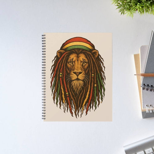 Notebook with a lion wearing a Rastafarian hat design on a white surface. Bob Marley Gift Merch The Banyan Tee