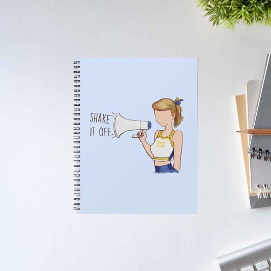 Taylor Swift Shake It Off spiral notebook with an illustrated cheerleader shouting through a megaphone on a light blue cover – The Banyan Tee